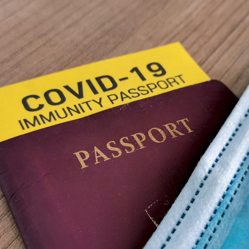 Close-up cropped image of covid-19 passport with yellow immunity card certificate.